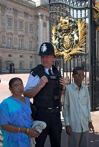 Turyści fotografujący się z Londyńskim policjantem.